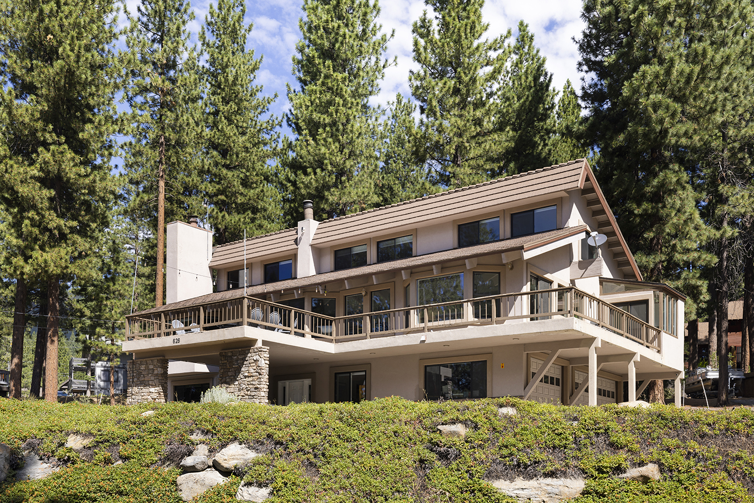 Kinpine House by daylight, its long deck among tall pines